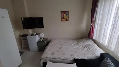 a small bedroom with a bed and a flat screen tv at Burgas Central-Sheynovo in Burgas City