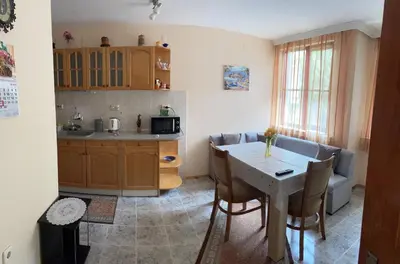 a kitchen and living room with a table and a couch at Mariana Guest House Къща за гости Марияна in Pomorie