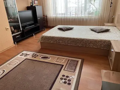 a living room with two beds and a television at Mariana Guest House Къща за гости Марияна in Pomorie