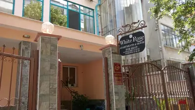 a building with a gate with a sign on it at White Rose Guest Rooms in Burgas City