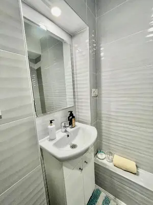 a white bathroom with a sink and a shower at White Rose Guest Rooms in Burgas City