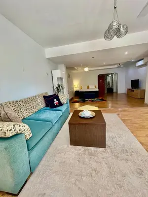 a living room with a blue couch and a table at White Rose Guest Rooms in Burgas City