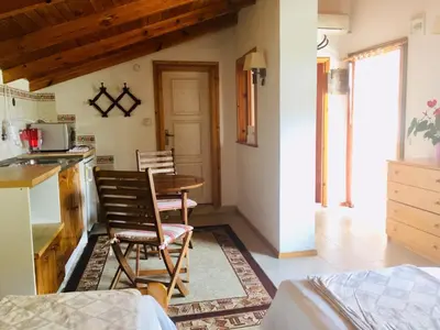 a kitchen with a table and chairs in a room at Guest House Barbov in Obzor