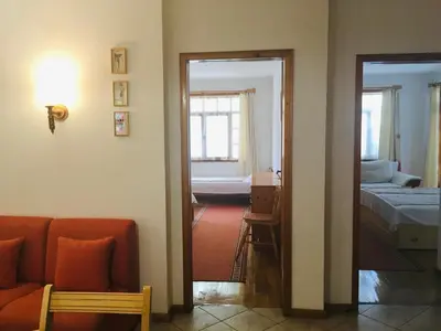 a living room with a couch and a bed and a mirror at Guest House Barbov in Obzor