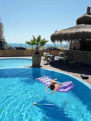 a woman laying on a raft in a swimming pool at Laguna Beach Hotel in Ravda