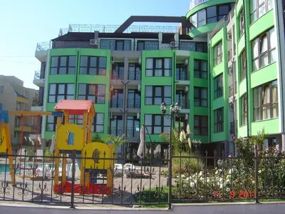 a green building with a fence in front of it at Laguna Beach Hotel in Ravda