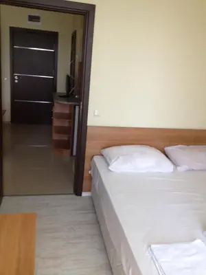 a bedroom with two beds and a door with a mirror at Laguna Beach Hotel in Ravda