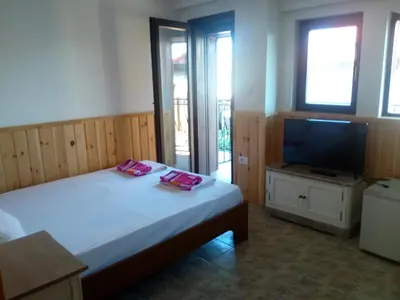 a bedroom with a bed and a flat screen tv at Rony Hotel in Nesebar