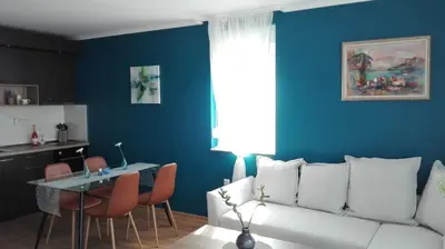 a living room with a white couch and a table at Azur Apartment Deluxe in Chernomorets