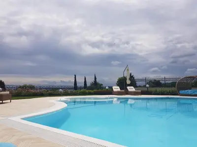 a large swimming pool with two chairs and a building at Azur Apartment Deluxe in Chernomorets