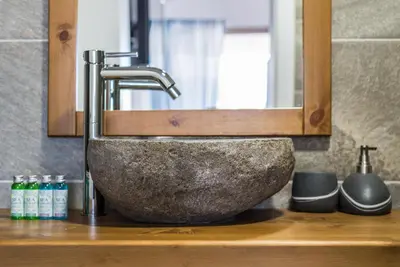 a bathroom sink with a stone sink at Camping Gradina in Sozopol