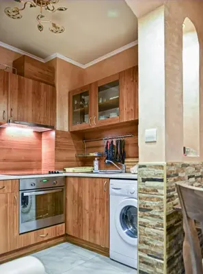 a kitchen with wooden cabinets and a washer and dryer at South Beach Vacation Apartments in Sunny Beach