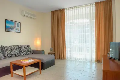 a living room with a couch and a tv at South Beach Vacation Apartments in Sunny Beach