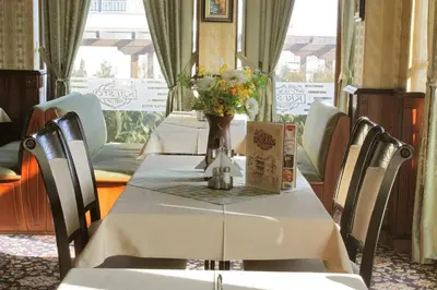 a table with chairs and a vase with flowers on it at Hotel Dukov in Obzor