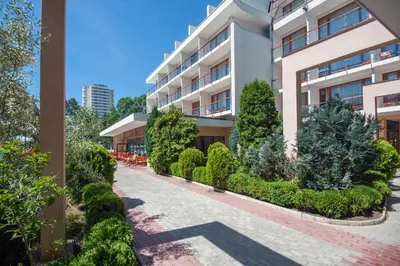 an apartment building with a courtyard with trees and bushes at Mercury Hotel- All Inclusive in Sunny Beach