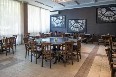 a dining room with tables and chairs and clocks at Mercury Hotel- All Inclusive in Sunny Beach