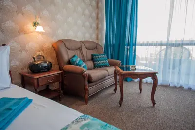a bedroom with a chair and a table and a bed at Mercury Hotel- All Inclusive in Sunny Beach