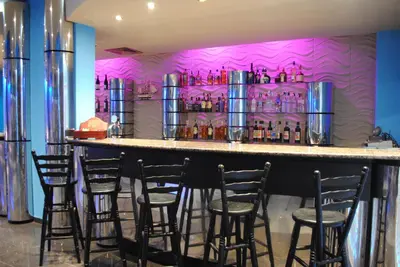 a bar with a bunch of bar stools in a room at Mercury Hotel- All Inclusive in Sunny Beach