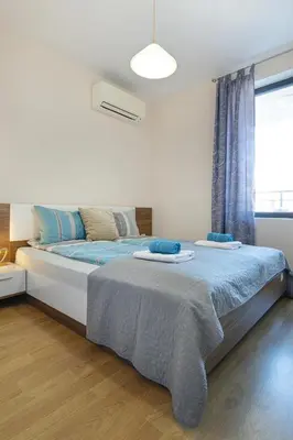 a bedroom with a bed with blue sheets and a window at The Captain Be my guests! by RV Apartments in Varna City