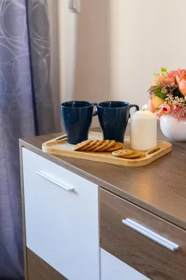 two blue cups and cookies on a wooden tray on a dresser at The Captain Be my guests! by RV Apartments in Varna City