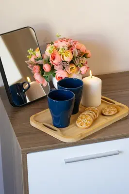 a tray with a candle and flowers and cookies at The Captain Be my guests! by RV Apartments in Varna City