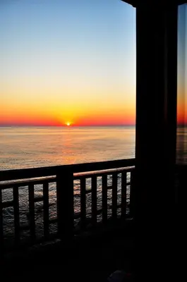 a sunset over the ocean from a balcony at Deep Blue Guest House in Sozopol