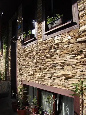 a stone building with potted plants on it at Deep Blue Guest House in Sozopol