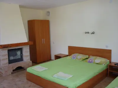 a bedroom with a large bed and a fireplace at Nimpha Bungalows in Kamchia