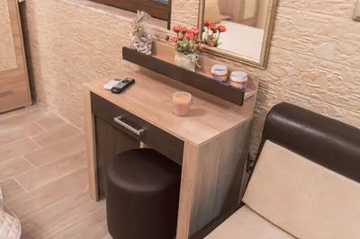 a room with a table with a mirror and a stool at Deluxe Studios City Center in Burgas City