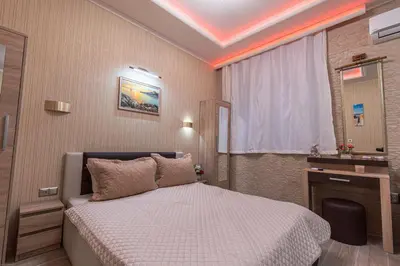 a bedroom with a bed and a desk and a window at Deluxe Studios City Center in Burgas City