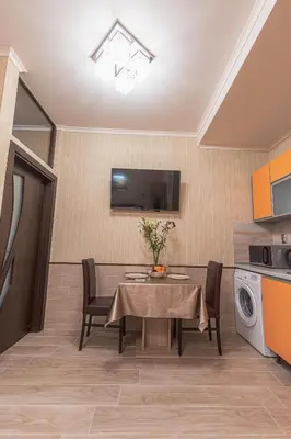 a dining room with a table and chairs and a tv at Deluxe Studios City Center in Burgas City