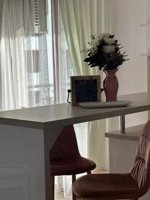 a table with a laptop and a vase with flowers on it at PANTELI APART HOUSE in Aheloy