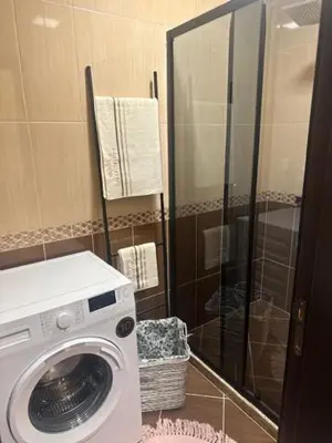a washing machine in a bathroom with a shower at PANTELI APART HOUSE in Aheloy