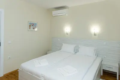 a bedroom with a white bed with two white pillows at Hiora Apartments Vasiliko in Tsarevo