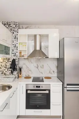 a white kitchen with a stove and a refrigerator at Hiora Apartments Vasiliko in Tsarevo
