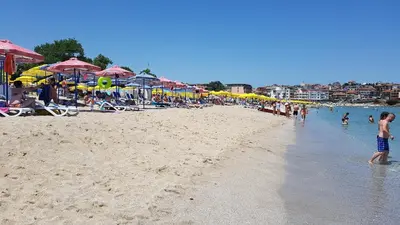 a group of people on a beach with umbrellas at Apartman Horizont II - side sea view in Sozopol