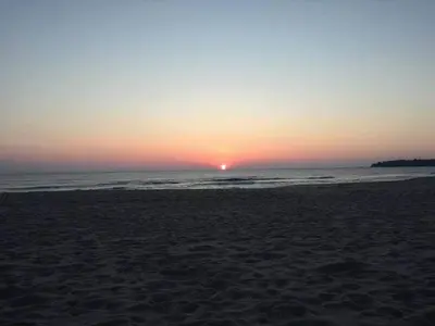 a sunset on a beach with the ocean at Apartman Horizont II - side sea view in Sozopol
