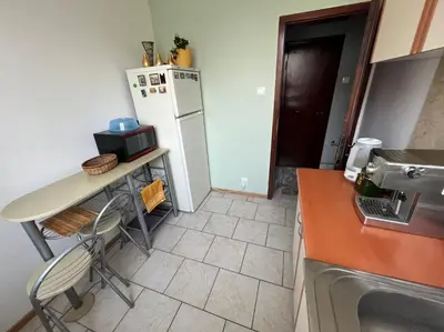 a kitchen with a table and a refrigerator at Izgrev Sarafovo in Burgas City