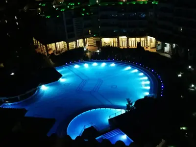 a large pool with blue lights at night at Emerald Beach Resort & Spa,studio ikat310 in Ravda
