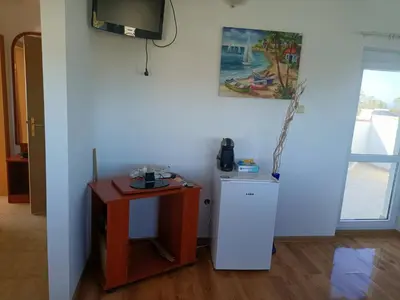 a room with a refrigerator and a table and a television at Beautiful Penthouse Apartment in Sunny Beach