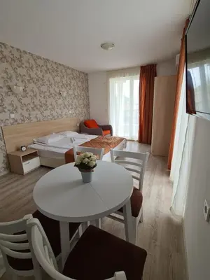 a room with a bed and a table and chairs at MIDA Apartment in Obzor