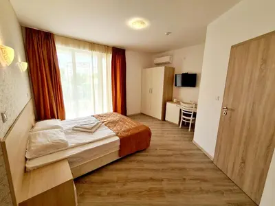 a hotel room with a bed and a window at MIDA Apartment in Obzor