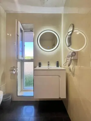 a bathroom with a sink and a mirror and a window at Ancient well in Sozopol