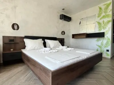 a bedroom with a large bed with white sheets at Ancient well in Sozopol