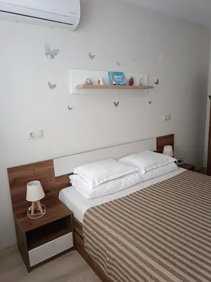 a bedroom with a bed and a shelf on the wall at Megi Luxury Apartments in Pomorie