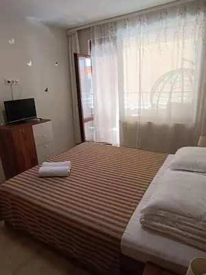 a bedroom with two beds and a window at Megi Luxury Apartments in Pomorie