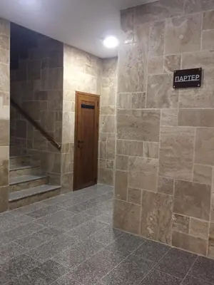 a lobby with a stone wall and a door at Megi Luxury Apartments in Pomorie