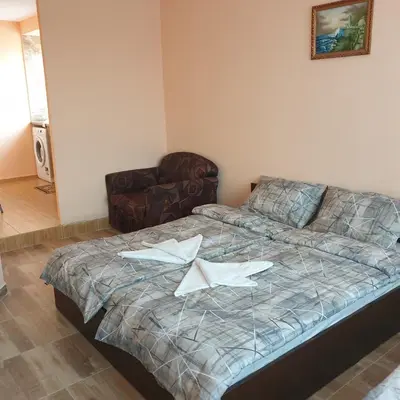 a bedroom with a bed with two white papers on it at Къща за гости Оазис in Pomorie