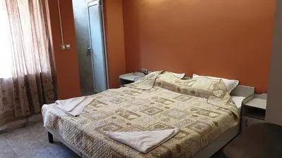 a bedroom with a bed and a window at Къща за гости Оазис in Pomorie