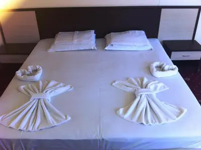 a white bed with two pillows with bows at Maverick Hotel in Sunny Beach